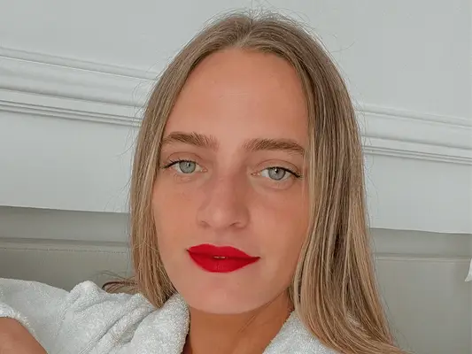 woman with tinted eyebrows and red lipstick looking at camera
