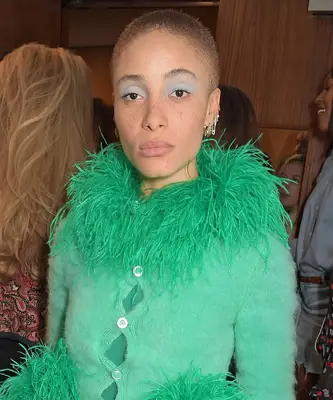 A model in green wears powder blue eye makeup