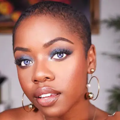 A woman wears blue eyeshadow with a dab of white