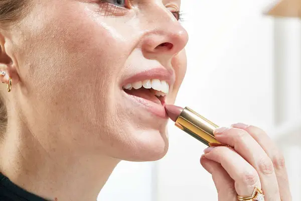 A person applies Merit Signature Lip Lightweight Lipstick
