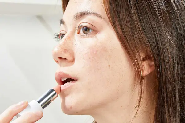 A person applies Makeup By Mario Ultra Suede Lipstick