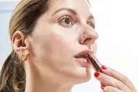 A person applies Charlotte Tilbury Matte Revolution Lipstick