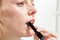 A person applies the Victoria Beckham Beauty Posh Lipstick