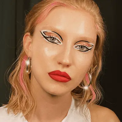 Model with sculptural winged eyeliner in white and black. 
