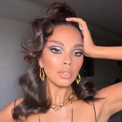 Model with silver metallic eyeshadow, black graphic crease liner, and neutral cheeks and lips