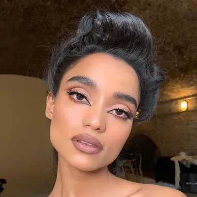 Model with mauve-toned makeup and reverse cat eye liner