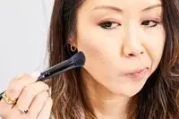 A person applies Anastasia Beverly Hills Powder Contour Kit powder to their face