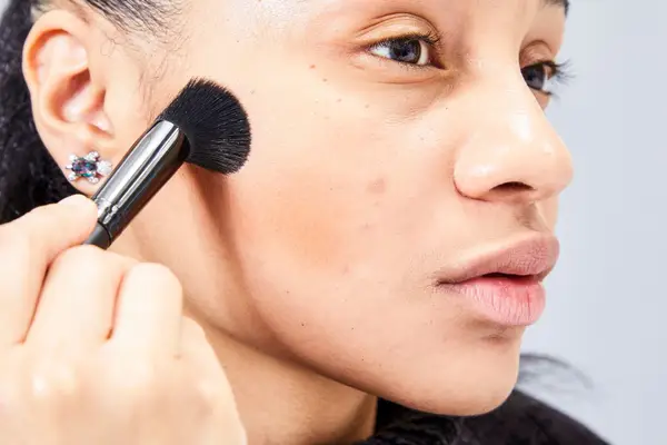 A person applies the Patrick Ta Major Sculpt Creme Contour & Powder Bronzer Duo