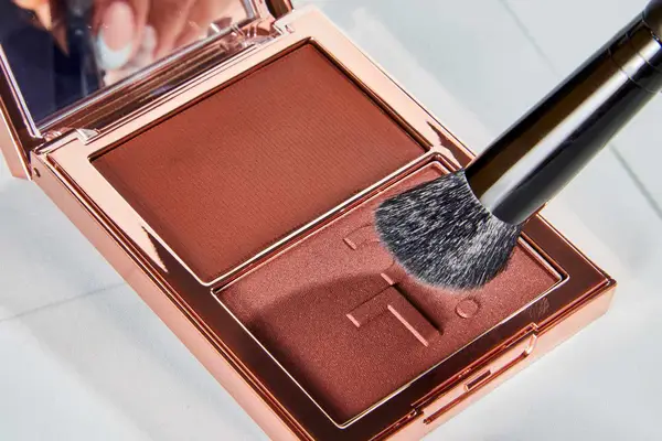 The Patrick Ta Major Sculpt Creme Contour & Powder Bronzer Duo is applies with a brush