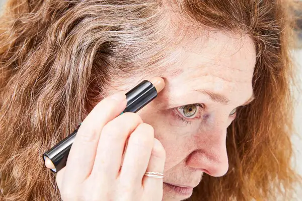 A person applies the NYX Professional Makeup Wonder Stick Contour & Highlighter Stick