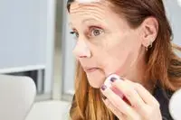 A person applies the KVD Beauty Shade + Light Powder Face Contour Palette