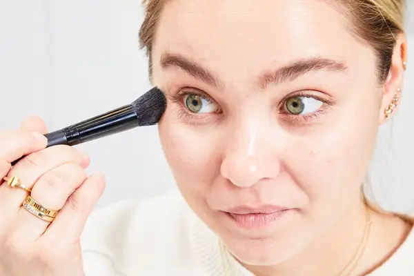 A person applies Charlotte Tilbury Filmstar Bronze & Glow Contour Duo