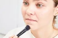 A person applies Charlotte Tilbury Filmstar Bronze & Glow Contour Duo