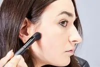 A person applies the Hourglass Ambient Lighting Palette