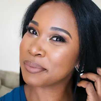 Woman with soft glam smoky eye, radiant skin, and neutral lipstick