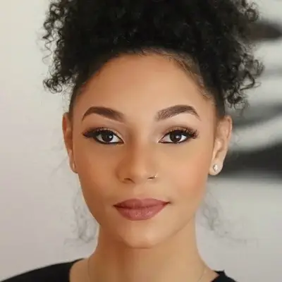 Woman with soft glam eyeshadow, neutral pink lips, and flushed cheeks