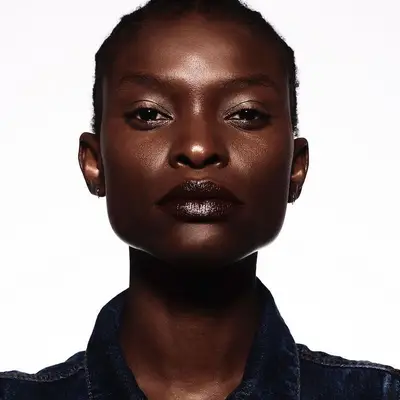 Model with subtle dark burgundy lipstick and radiant, rich skin