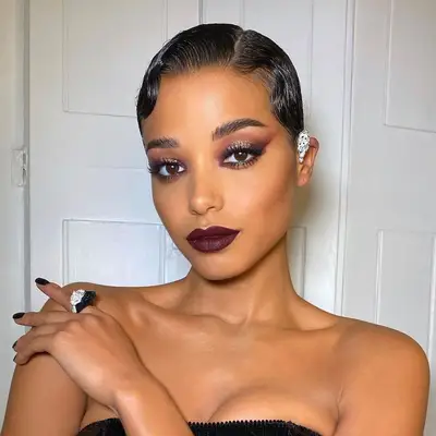 Ella Balinska wears burgundy shimmer smoky eyeshadow and burgundy lipstick