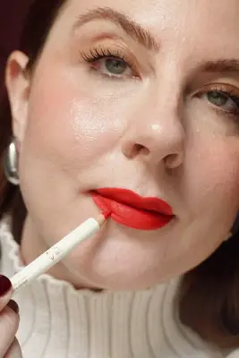 woman applying red lip liner to red lips