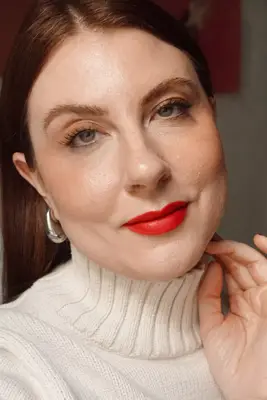 woman posing in a natural makeup look with a bold red lip