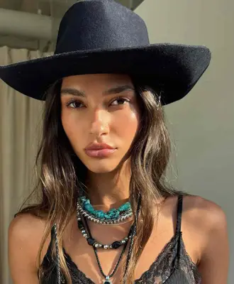 a woman in a hat with glowy makeup