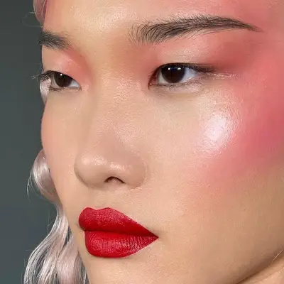 Model with airbrushed pink blush and red lipstick