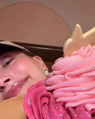 Hailey Bieber poses with some cupcakes.