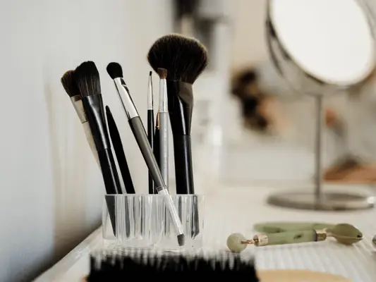 Makeup brushes with a mirror on a dresser 