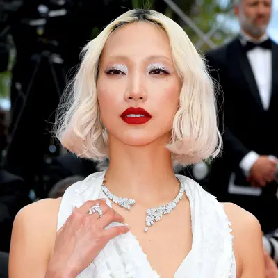 Soo Joo Park wears sparkling white eyeshadow, red lipstick, and a platinum bob
