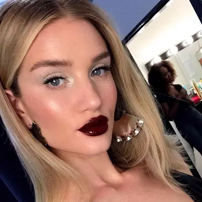 Rosie Huntington-Whiteley wears sheer white eyeshadow and glossy burgundy lipstick