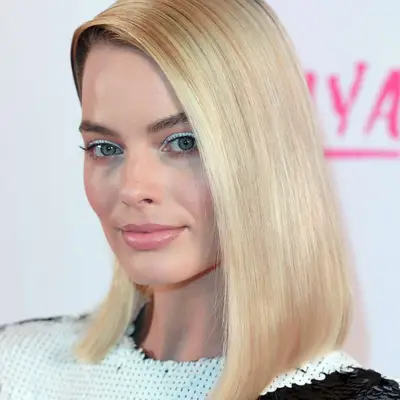 Margot Robbie wears simple white eyeshadow and subtle pink blush and lipstick