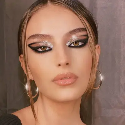 Woman with black smoky graphic cat eye and white gemstones