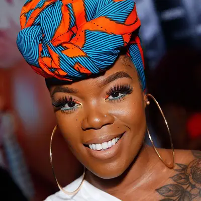 A woman in orange and blue eyeliner