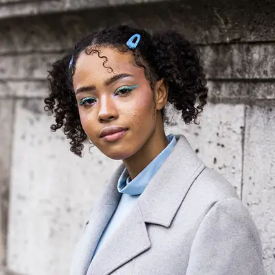 A young woman wearing pastel blue eyeshadow