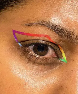 model is wearing an abstract eye look with purple, blue, orange, red, yellow, and green outlining the shape of the eye