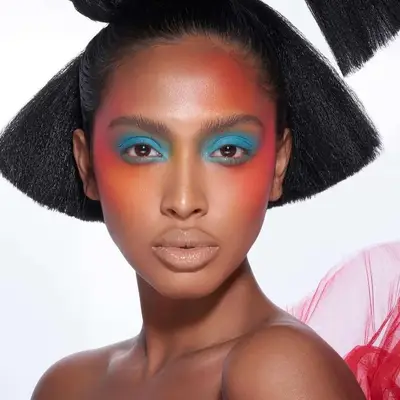 A makeup look with dramatic sunset blush and blue eyeshadow