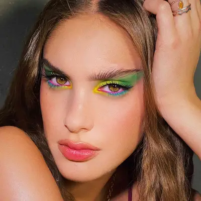 A yellow, green, pink, and blue eyeshadow look in a cat-eye shape