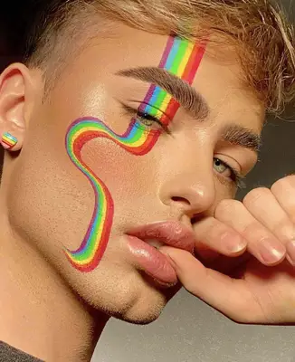 model displays a painted rainbow on one side of the face starting at the forehead and moving down the cheek to the chin