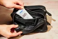 A person taking sunscreen out of the Royce New York Double Zip Leather Toiletry Bag