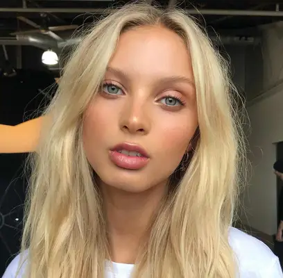 model wears natural makeup look with nude eyeshadow, minimal mascara and light pink lips