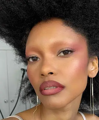 model wears nude eyeshadow look with visible mauve blush, lipstick and mascara