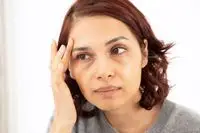 BareMinerals Complexion Rescue Tinted Moisturizer displayed on marble countertop with nearby makeup brush