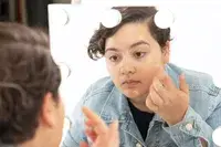 NARS Pure Radiant Tinted Moisturizer SPF 30 displayed next to a makeup sponge on marble countertop