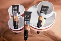 Person applying Honest Beauty CCC Clean Corrective with Vitamin C Tinted Moisturizer SPF 30 to face while looking into mirror