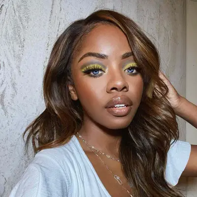 Woman with blue eyes and gray and yellow eyeshadow.