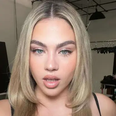 Woman with blue eyes and a silver pinky eyeshadow look.