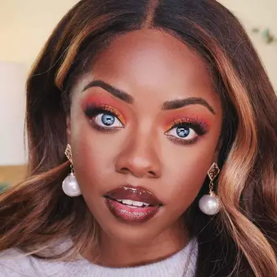 Woman with blue eyes and a soft orange-red eyeshadow look.