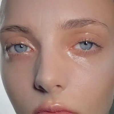 Woman with blue eyes and a soft sheen, shiny eyeshadow look.