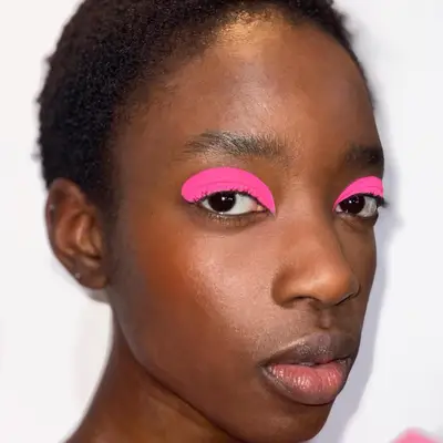 Woman with bright neon pink eyeshadow and radiant skin