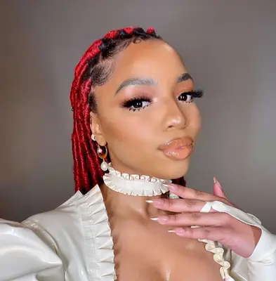 chloe bailey with red locs and neutral makeup